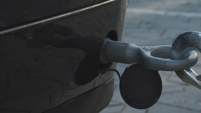 Attaching Tow Rope Hook to Rear Towing Eye of Car, Close-up Preparation for Vehicle Towing