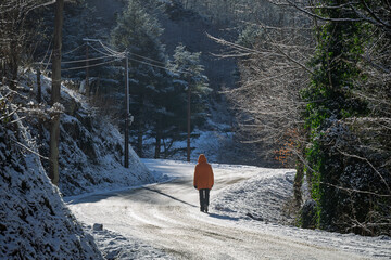 Woman walking on an icy mountain road