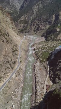 Vertical Aerial View of Winding River Flowing Through Mountain Valley