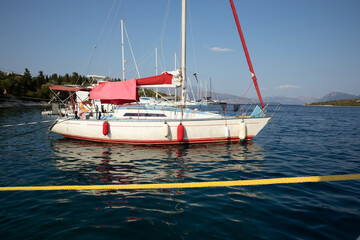Moored sailboats on the coast of Atherinos Bay, Meganisi island, Ionian Sea, Greece.