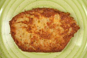A single golden brown slice of french toast served on a light green ceramic plate viewed from above
