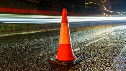 Traffic Cone on Wet Road with Light Trails