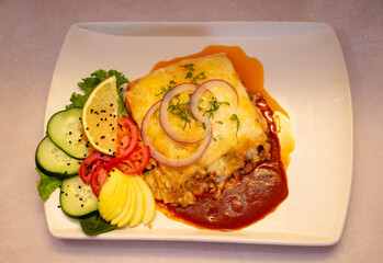 Plato toma cenital de una lasa&ntilde;a con ensalada fresca y deliciosa