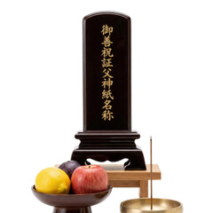 Japanese Buddhist memorial tablet ihai with incense and fruit offerings isolated on black