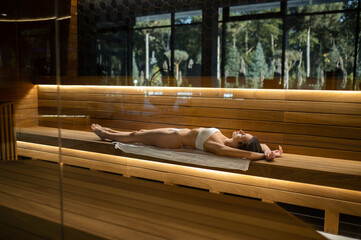 Slim woman lying on a bench in a spa salon and enjoying the procedures