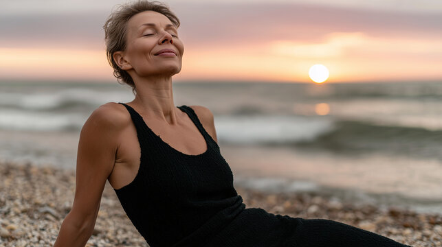 Senior woman sitting on the beach by the sea in a meditation pose enjoying the sunset calm serenity and seaside aesthetic - Powered by Adobe