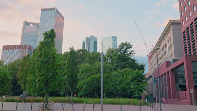 FRANKFURT, GERMANY - AUGUST 15, 2025: Vertical tilt-up view of skyscrapers in financial district. Cinematic city skyline B-roll footage for news, documentaries, and travel reports at daylight.