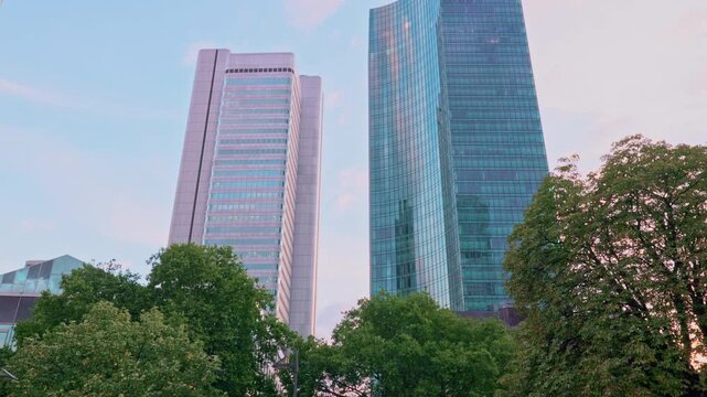 FRANKFURT, GERMANY - AUGUST 15, 2025: Vertical tilt-up view of skyscrapers in financial district. Cinematic city skyline B-roll footage for news, documentaries, and travel reports at daylight.