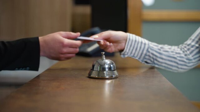 Hotel concierge handing key card to guest at reception desk