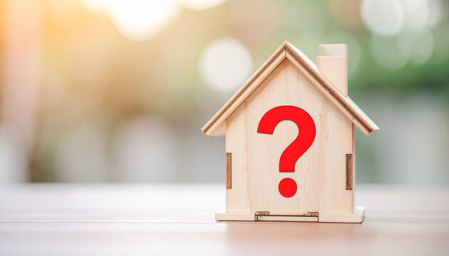 Miniature wooden house with red question mark, real estate property concept, soft background