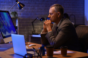 Male business analyst working in office at night. Data science concept