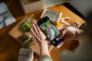 Adult focused photographing hand with ring at home