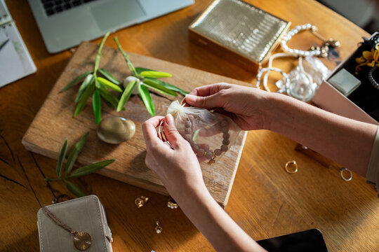 Adult hands focused packing bracelet gift at home studio