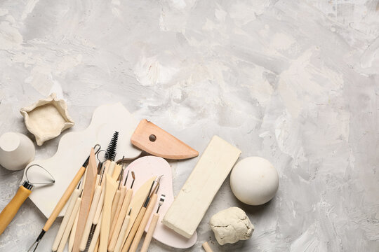 Set of sculptor tools with plaster figures and clay on white grunge background