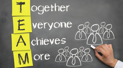 Hand draws business team on chalkboard with TEAM sticky notes and motto Together Everyone Achieves More