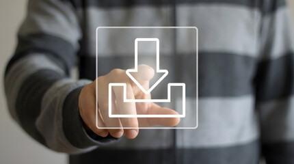 A persons hand touches a glowing white download symbol on a translucent virtual screen representing digital technology and data processing