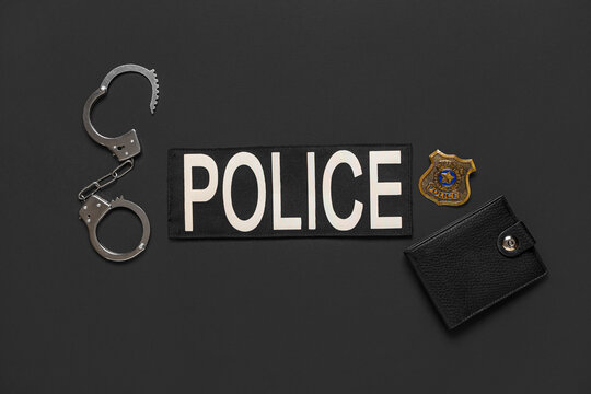 Wallet with policeman's items on black background