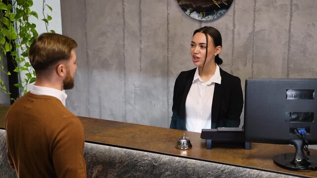 Hotel receptionist greeting guest and providing room key card