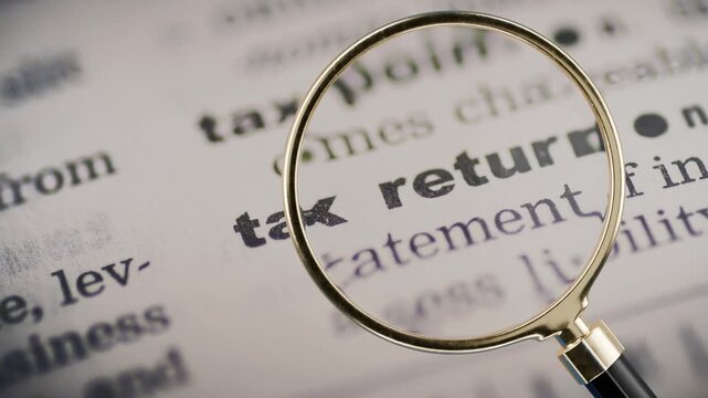 magnifying glass hovering over paper article that says tax return, paying taxes