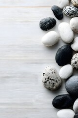 Overhead View of Smooth Dark Gray and Light Gray Pebbles Artistically Arranged on a Pale Wood Background for Tranquil Decor and Balance