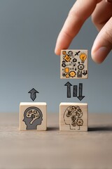 A person's hand placing wooden blocks with a head symbol, representing the process of knowledge transfer and skill exchange