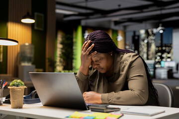 African american drained woman experiencing weariness after hours at desk, falling asleep with head in her palm. Overwhelmed anxious and fatigued worker deals with burnout and mental haze.
