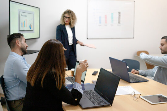 Businesswoman presenting data to diverse team at office meeting - Powered by Adobe
