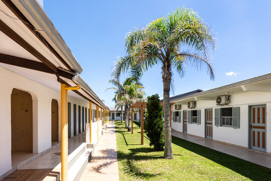Sunny aisle in vintage hotel patio, doors facing palms in perspective