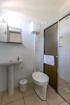 Clean and bright hotel bathroom with shower, toilet and sink