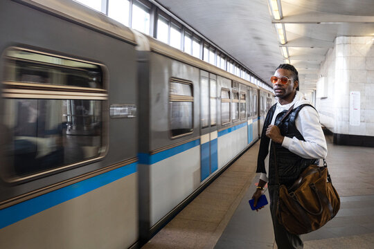 Man Waiting at Subway Station With Train Approaching