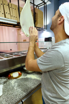 young chef throws up the pizza dough