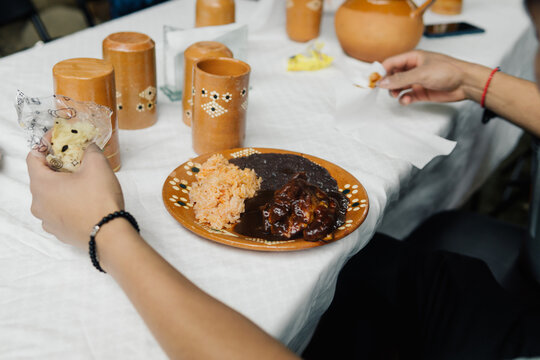 A person sittimg on at a table with mexican food