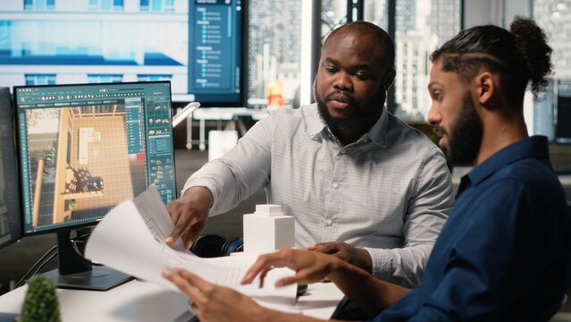 Engineer and designer working together on real estate interior design, using software for professional layout and structure. Creating master plans and reviewing construction blueprints.