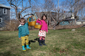 Kids show their Easter baskets while doing an egg hunt outside