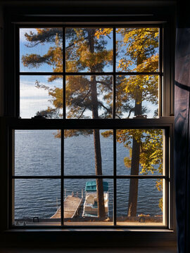 Scenic Lake View Through Window With Autumn Trees in Sunlight