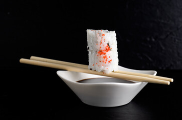 Side View of Salmon Sushi on with White Bowl of Soya Sauce
