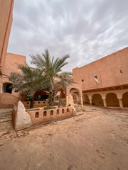 Traditional courtyard architecture with a palm tree and arches in the historic Ghardaia region of Algeria.