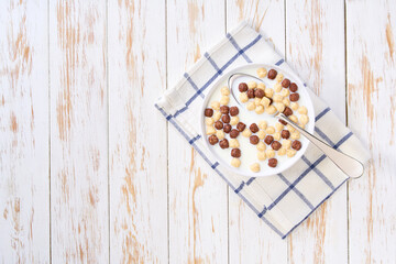 Healthy breakfast, bowl of corn balls and chocolate corn balls with milk . Top view.