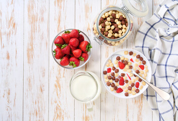 Healthy breakfast with  corn balls with two flavors and strawberry on a white wooden table, top view.