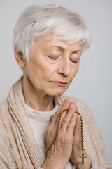 Elderly Woman Praying with Rosary Beads in Quiet Reflection