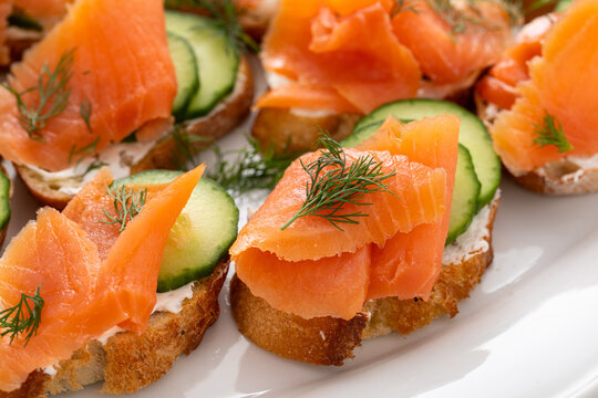 Smoked salmon crostini with cream cheese, fresh cucumber and dill closeup