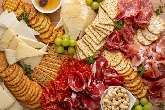 Charcuterie and cheese board with variety of meat and cheeses, crackers and nuts