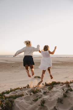 Little Girls Jumping on Sand Dunes