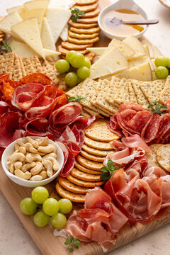 Charcuterie and cheese board with variety of meat and cheeses, crackers and nuts