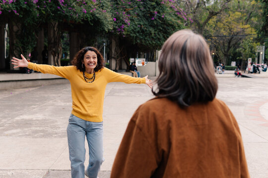 Woman smiling with open arms for hug.