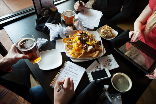 Bar: Business People Having Lunchtime Brainstorming Session At Bar