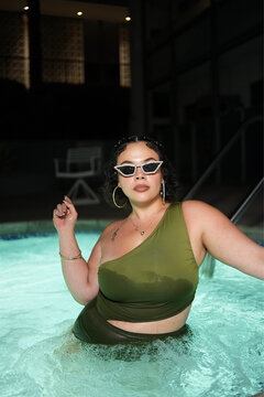 Woman in Green Swimsuit Standing in Night Pool