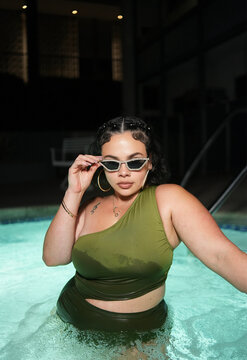 Woman Adjusting Sunglasses in Night Pool