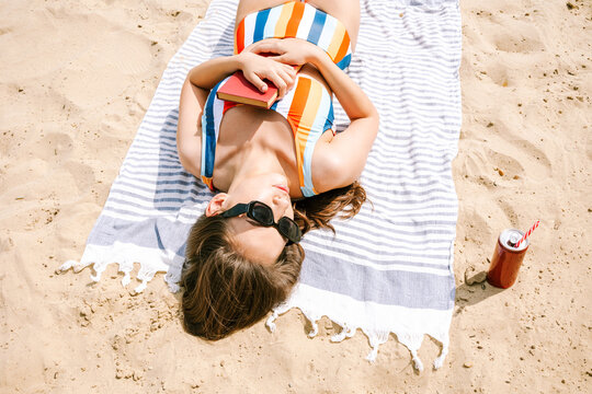 Woman relaxing on the beach with a book