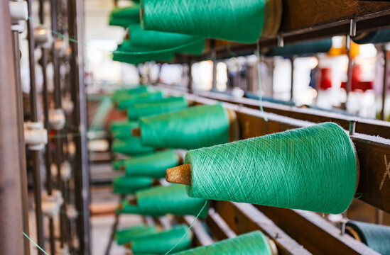 Green Spinning Threads Arranged in a Textile Factory Setting